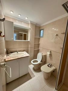 a bathroom with a toilet and a sink and a shower at 1st Line Beach Direct Access Private Parking in Valencia +17 photos