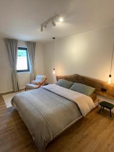 a bedroom with a large bed and a chair at Alpine Hideaway in a 1700's Borgata in Bussoleno