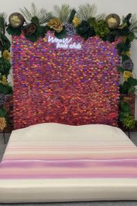 a bed in front of a wall covered in confetti at WooW kids club in Rīga