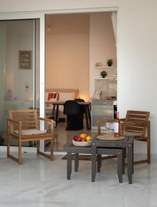 a living room with chairs and a table with fruit on it at Seaside Breeze Studio in Agios Nikolaos