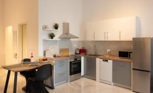 a kitchen with white cabinets and a table in it at Seaside Breeze Studio in Agios Nikolaos