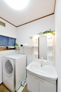 Un baño con lavabo y lavadora. en Tsumugu art base, en Osaka 19 fotos más