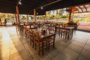 a restaurant with wooden tables and chairs on a tiled floor at Gaúcha Pesca, Lazer e Pousada in Guaíra