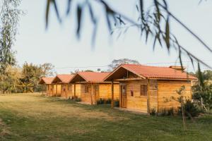 a row of wooden cabins with red roofs at Gaúcha Pesca, Lazer e Pousada in Guaíra