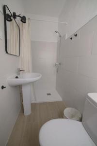 a white bathroom with a toilet and a sink at Gran alojamiento a 1 metro de la playa con magnificas vistas in Chipiona