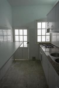 a white kitchen with a counter top and two windows at Gran alojamiento a 1 metro de la playa con magnificas vistas in Chipiona +12 photos