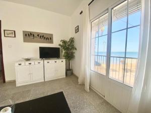 a living room with a television and a large window at Gran alojamiento a 1 metro de la playa con magnificas vistas in Chipiona