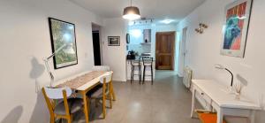 Una habitación con una mesa y sillas y una cocina. en Departamento céntrico Pioneros y Campichuelo, en San Carlos de Bariloche 2 fotos más