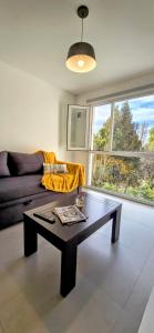 Una sala de estar con una mesa de centro y un sofá en Departamento céntrico Pioneros y Campichuelo, en San Carlos de Bariloche