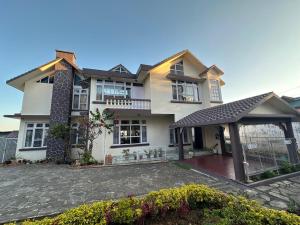 a large white house with a large driveway at Beaumont Homestay 377 in Shillong