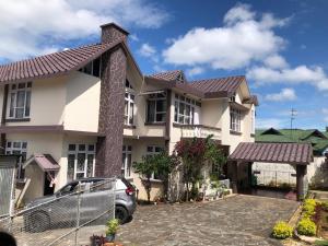 a house with a car parked in front of it at Beaumont Homestay 377 in Shillong +8 photos