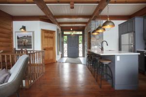 una cucina con un bar e un divano in una casa di Log cabin - Lakeside - Le Oly a Saint Romain Altre 42 foto