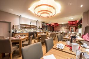 ein Restaurant mit Holztischen und -stühlen und einer Bar in der Unterkunft Hotel Bachmühle in Fulda