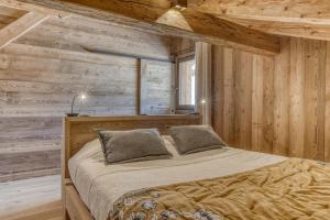 una camera da letto con un letto in una parete di legno di Chalet le Plane a Saint-Gervais-les-Bains