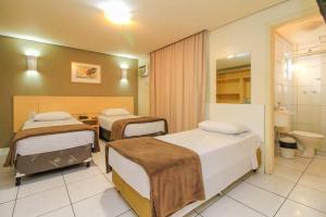 a hospital room with two beds and a toilet at Coral Express próximo ao Parque Harmonia e Beira Rio in Porto Alegre +37 photos