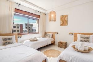 丹吉尔Tanger Marina - 2 Floor Luxury Penthouse with Terrace - Fantastic Location的有两张床和一扇窗户的卧室