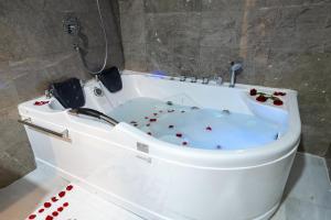a white bath tub with red flowers in it at Dancenter Jeddah Luxury Hotel in Jeddah +37 photos