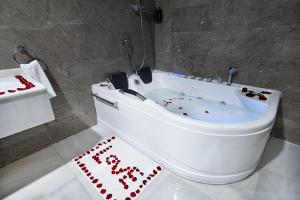 a white bath tub with a happy birthday sign in a bathroom at Dancenter Jeddah Luxury Hotel in Jeddah