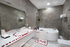 a bathroom with two sinks and a tub and a toilet at Dancenter Jeddah Luxury Hotel in Jeddah