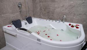 a white bath tub with red flowers in it at Dancenter Jeddah Luxury Hotel in Jeddah
