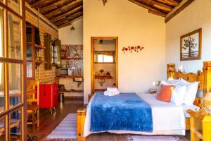 a bedroom with a bed with a blue comforter at Pousada Chales Rancho Caipira in Santo Antônio do Pinhal