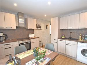 a kitchen with white cabinets and a table with chairs at Ferienwohnung Christina in Friedrichroda in Friedrichroda
