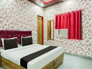 a bedroom with a large bed with red curtains at Hotel O Astoria in Zirakpur