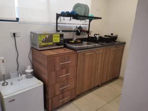 a kitchen with a sink and a microwave on a counter at Aparta-estudio cerca UPTC, clínica de los andes in Tunja +3 photos
