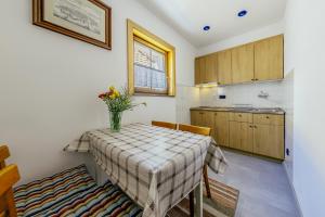 a kitchen with a table with a vase of flowers on it at River Side Holiday Home near Besenova in Ivachnová
