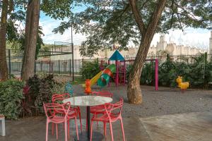 a table and chairs in a park with a playground at Hotel Manantial Valencia in Valencia