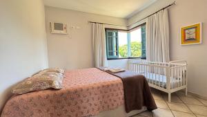 Ένα ή περισσότερα κρεβάτια σε δωμάτιο στο Refugio Completo Piscina Privativa, Ar-Condicionado em Todos os Espaços Churrasqueira, Jardim e Enxoval Incluso 200m da Praia +55 φωτογραφίες