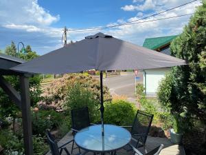 a table and chairs with an umbrella on a patio at Wohnung nahe Inselsberg Wanderwege in Waltershausen