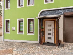 a green building with a door in front of it at Wohnung in Stützerbach nahe Skipiste in Stützerbach +20 photos