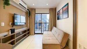 a living room with a couch and a tv at Buenos Ayres Cabo Branco Genius Flats in João Pessoa