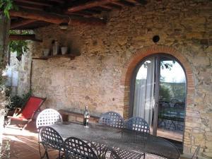 un patio avec une table et des chaises et un mur en pierre dans l'établissement Appartamento Blu, à San Donato in Poggio