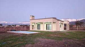 a small white house with a swimming pool in a yard at El Rincón de Gemma in Salta