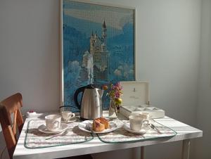 a table with a tea set with a tea kettle and cups at La Casa di Cristina in Martellago +19 photos