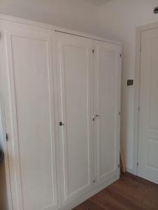two white closet doors in a room with wood floors at La Casa di Cristina in Martellago