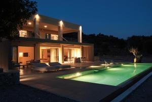 a house with a swimming pool in front of a house at Alykes Villa - Seaview escape in Plakias