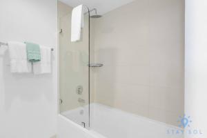 a shower with a glass door in a bathroom at Balcony with Infinite Views - Poolside Comfort in Hallandale Beach
