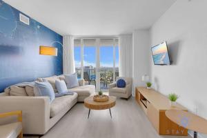 a living room with a couch and a table at Balcony with Infinite Views - Poolside Comfort in Hallandale Beach