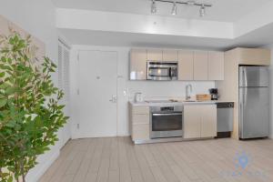 a kitchen with white cabinets and stainless steel appliances at Balcony with Infinite Views - Poolside Comfort in Hallandale Beach +48 photos
