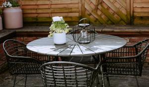 a metal table with chairs and a table with flowers on it at GLC2K Im FRTZ in Rietberg