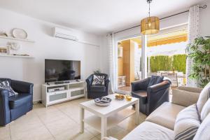 a living room with a couch and chairs and a tv at El Velero in El Tosalet