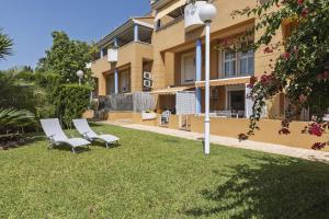 two chairs sitting in the grass in front of a building at El Velero in El Tosalet