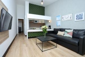 a living room with a black couch and a table at Sahara Beach Club in Maspalomas
