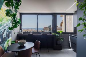 a dining room with a table and a large window at Tropicalia Suites by Wonderful Italy in Aci Castello