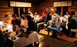 un gruppo di persone sedute ai tavoli di un ristorante di Peurakaltio Arctic Retreat a Muonio