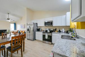 eine Küche mit weißen Schränken und Geräten aus Edelstahl in der Unterkunft Greenville Getaway Close to Campus and Stadium! in Greenville