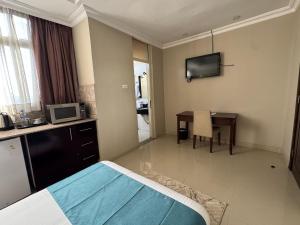 a hotel room with a bed and a table and a television at Beta Guesthouse in Addis Ababa